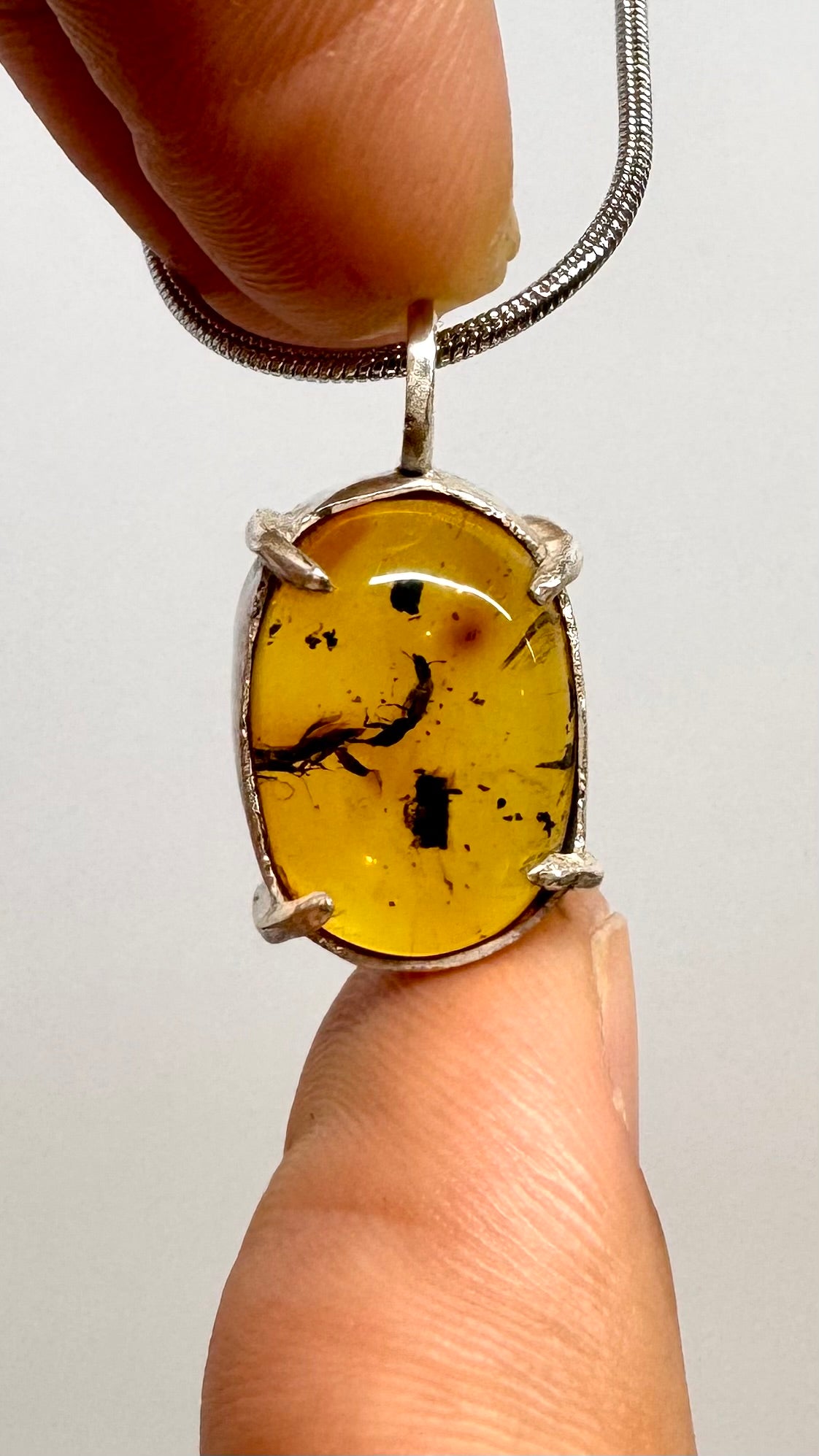 Dije de Ámbar pequeño con dos insectos. Plata.