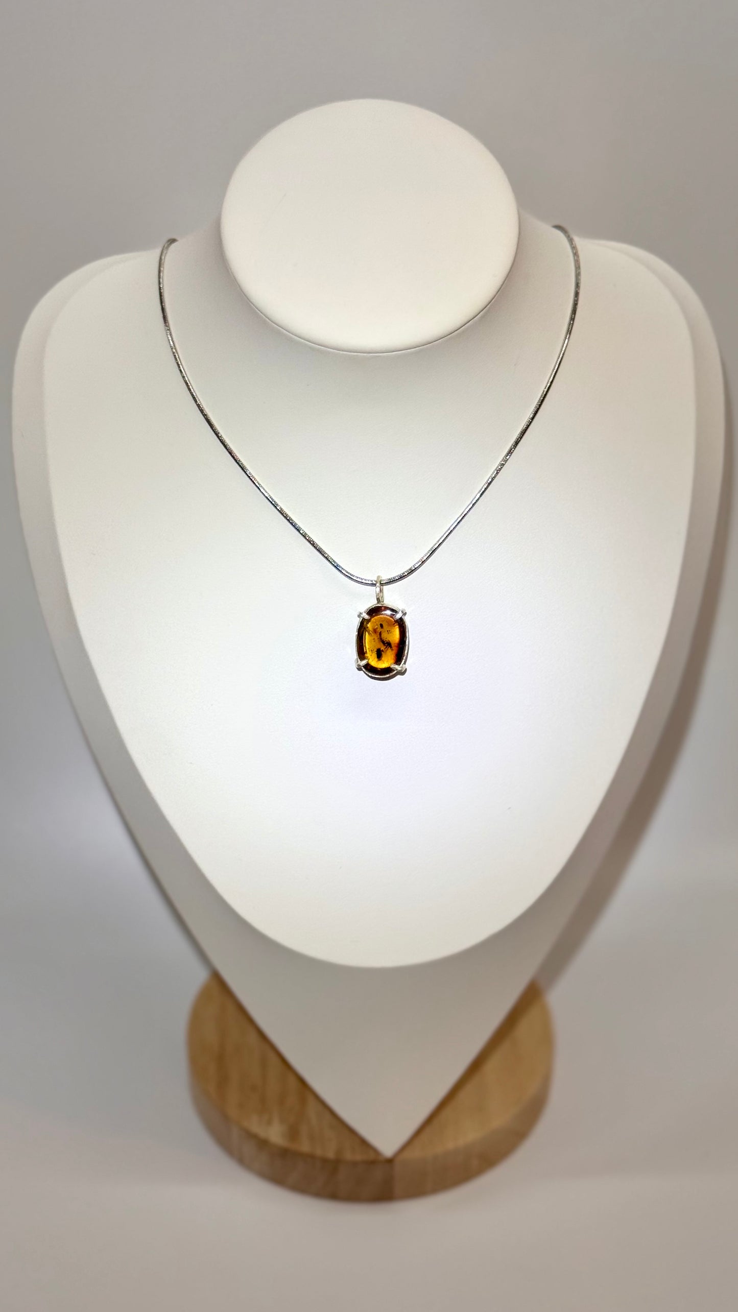 Dije de Ámbar pequeño con dos insectos. Plata.