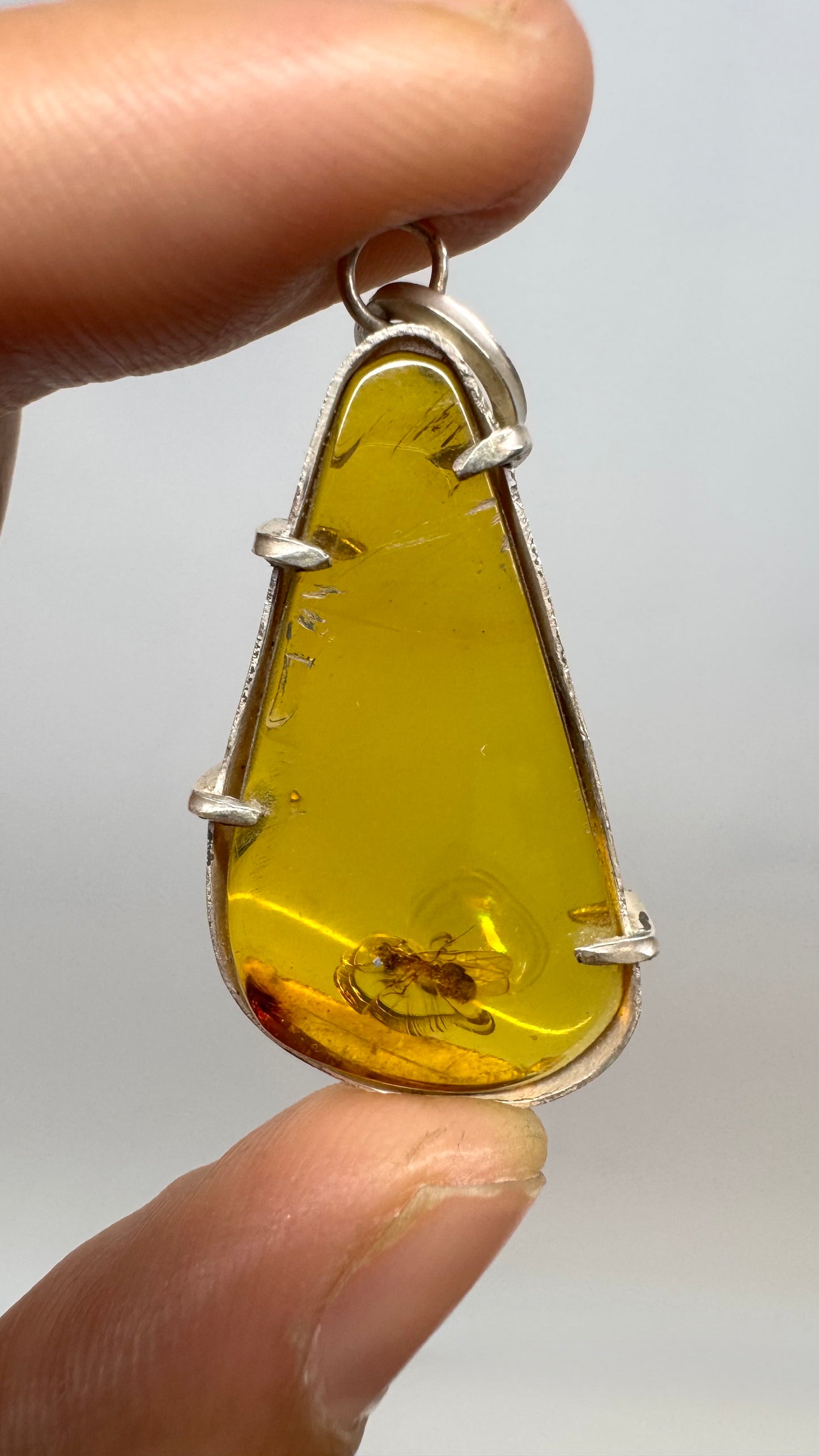 Pendentif en ambre avec mouche primitive en argent